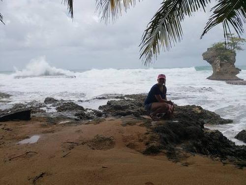 Kelli Dykstra on rocks in front of the ocean